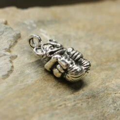 Gripping Bear Pendant -The Viking Dragon ad silver gripping bear pendant on rock side view