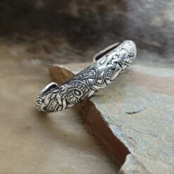 Silver Runic Viking Bracelet / Arm Ring -The Viking Dragon ad silver runic arm ring on rock front angle view