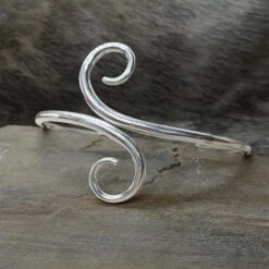 Hand Forged Silver Viking Arm Ring / Arm Band -The Viking Dragon bt silver hand forged twisted viking arm ring on rock front view