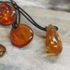 Amber Amulet Pendant -The Viking Dragon eg medium amber amulet pendants on rock side view