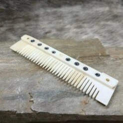 Medium Decorated Bone Viking Comb 9 Medium Decorated Bone Viking Comb -The Viking Dragon pm medium bone comb on rock angled view
