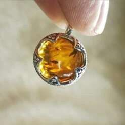 Silver Gotland Filigree Amber Ball Pendant 9 Silver Gotland Filigree Amber Ball Pendant -The Viking Dragon sn amber ball pendant in fingers