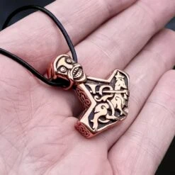 Bronze God Beast Thors Hammer Pendant 8 Bronze God Beast Thors Hammer Pendant -The Viking Dragon sn bronze godbeast thors hammer replica from norway on leather thong on hand angle view
