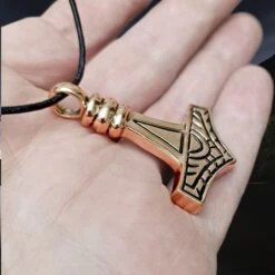 Large Bronze Gotland Replica Thors Hammer Pendant 11 Large Bronze Gotland Replica Thors Hammer Pendant -The Viking Dragon sn bronze large gotland hammer front side angle view on hand on leather thong