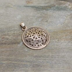 Bronze Sun Wheel Pendant -The Viking Dragon sn bronze sunwheel pendant on rock front angle view