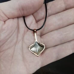 Oseberg Bronze Viking Ship Pendant -The Viking Dragon wl bronze oseberg viking ship pendant on leather thong on hand back view