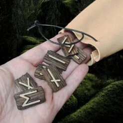 Elder Futhark Wooden Rune Set In Leather Pouch -The Viking Dragon wl wooden elder futhark runes in hand with medium leather pouch close up